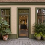 Façade élégante d’un institut de beauté à Bailleul, décorée de plantes vertes dans des tons beige et olive, au cœur d’une rue flamande lumineuse.